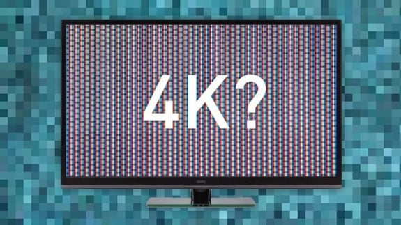 a monitor with 4k text in the screen has a background of blurred lines