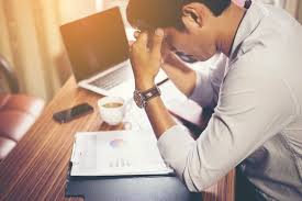 man is leaning on desk with paper works