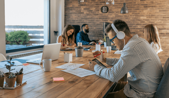 man-working-with-tablet-and-headphones-in-an-offic-2021-08-29-23-36-30-utc-min